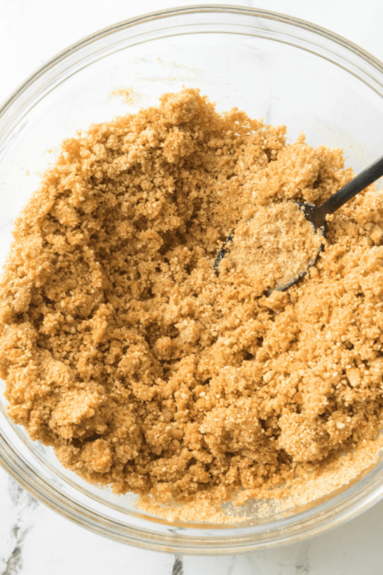 Close-up of graham cracker crust pressed into springform pan for cheesecake