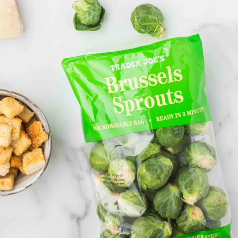 Ingredients for Lazy Dog Brussels sprouts recipe including fresh Brussels sprouts, butter, lemon, garlic, capers, bread, and Pecorino Romano