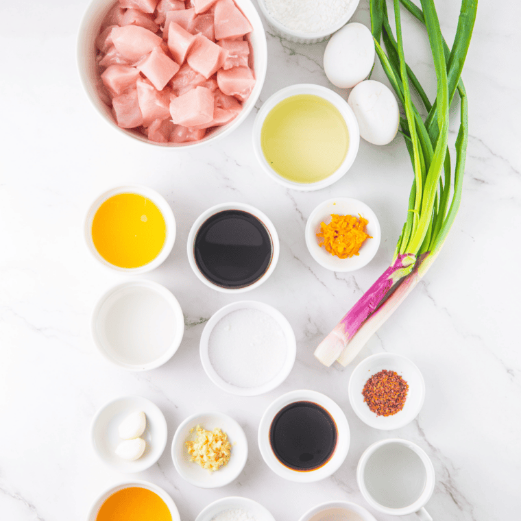 "Ingredients for slow cooker orange chicken including raw chicken, fresh oranges, soy sauce, honey, garlic, and ginger" &mdash; best default; keyword up front plus an honest description