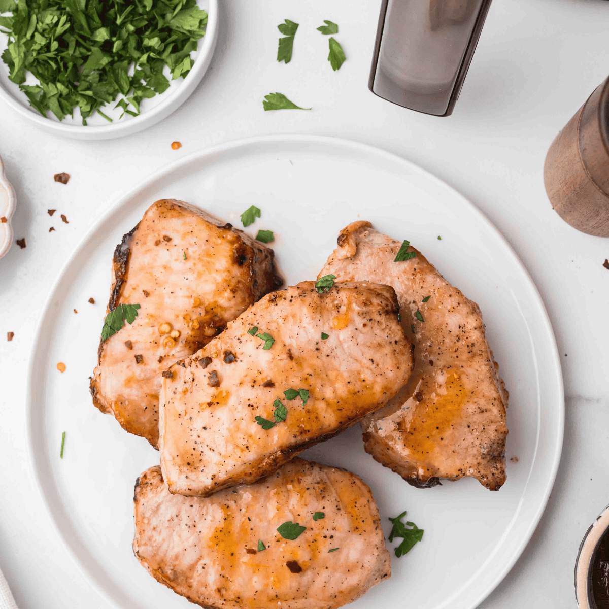 Cooked air fryer pork chops resting on a plate before serving