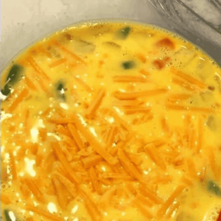 Fold diced bell peppers, onions, and shredded cheese into eggs