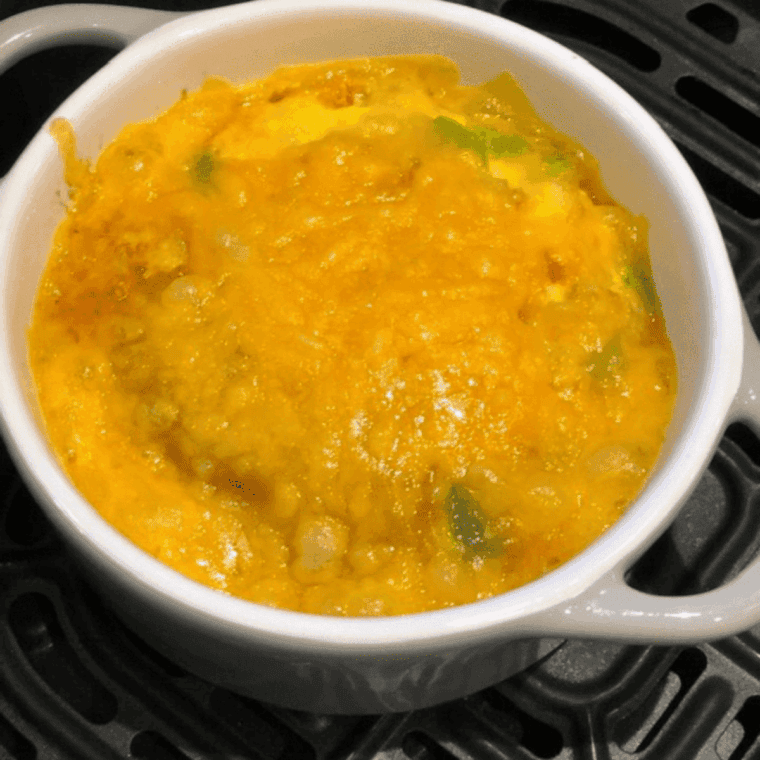 Air fryer vegetable omelet with peppers, onions, and melted cheese.