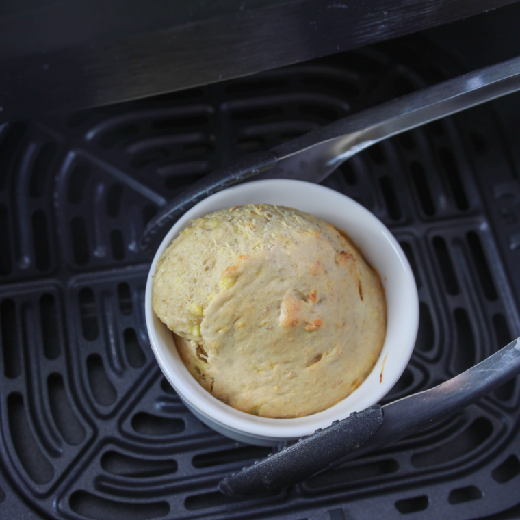 Baked air fryer banana bread mug cake with a golden top, resting after cooking  