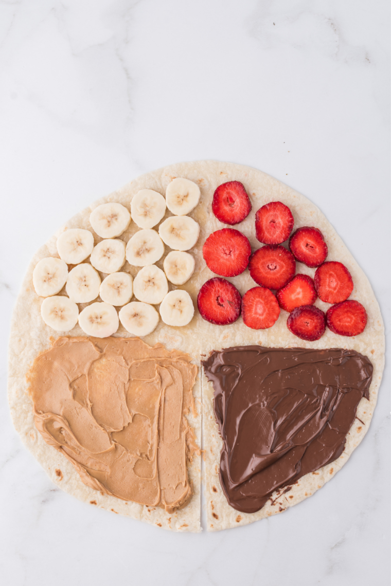 Nutella spread over half a flour tortilla with a clean half-inch border left around the edge