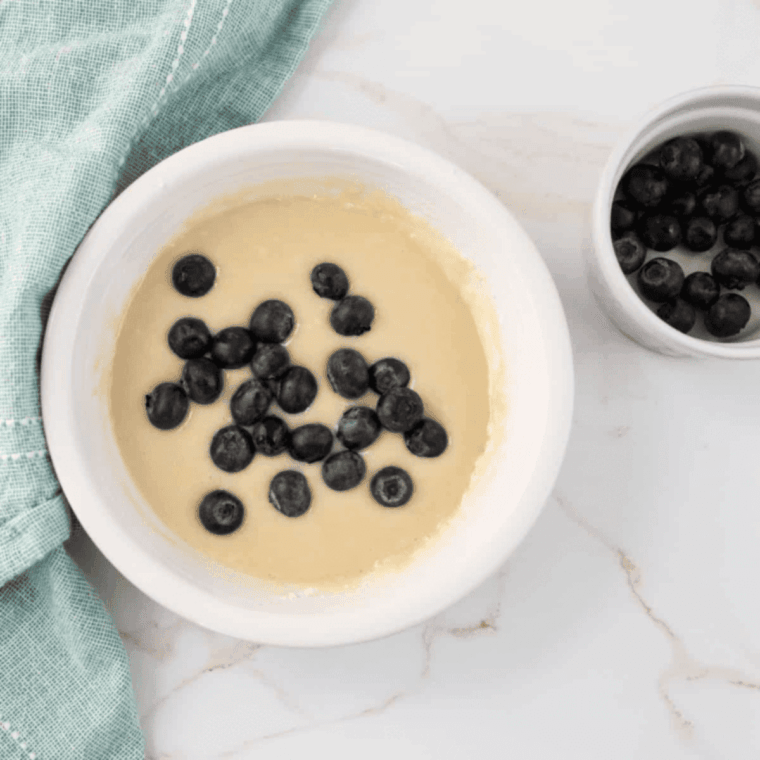 Mixing milk and melted butter into batter with blueberries
