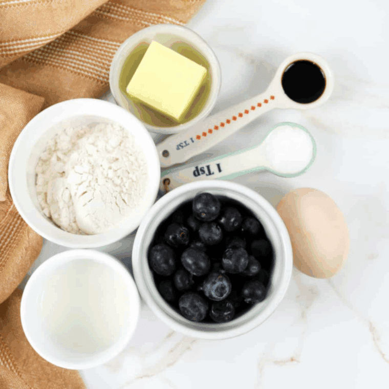 Ingredients needed for Air Fryer Blueberry Pancake Muffins on kitchen table.