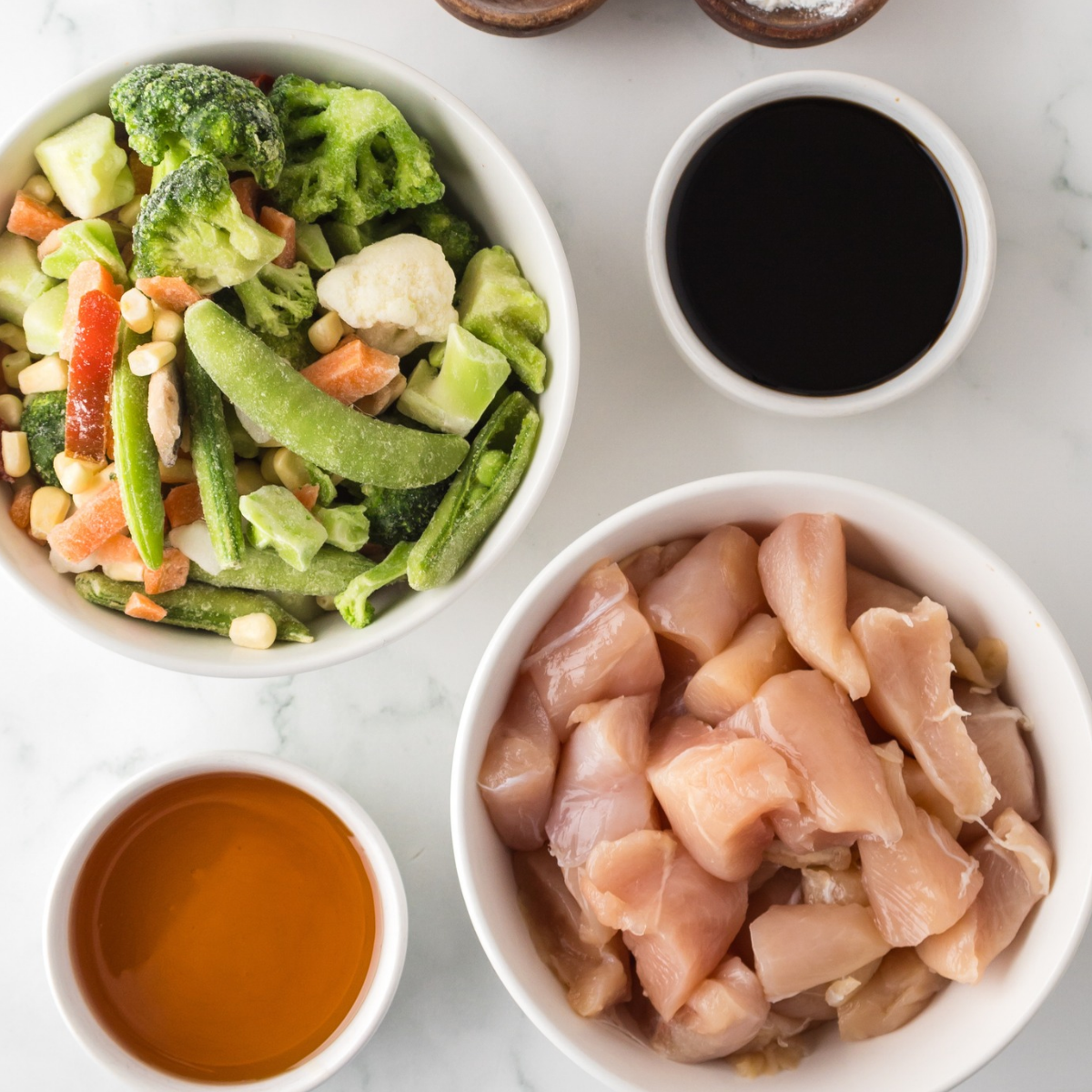Ingredients for air fryer chicken and broccoli: cubed chicken breast, broccoli florets, soy sauce, honey, garlic, ginger and rice vinegar