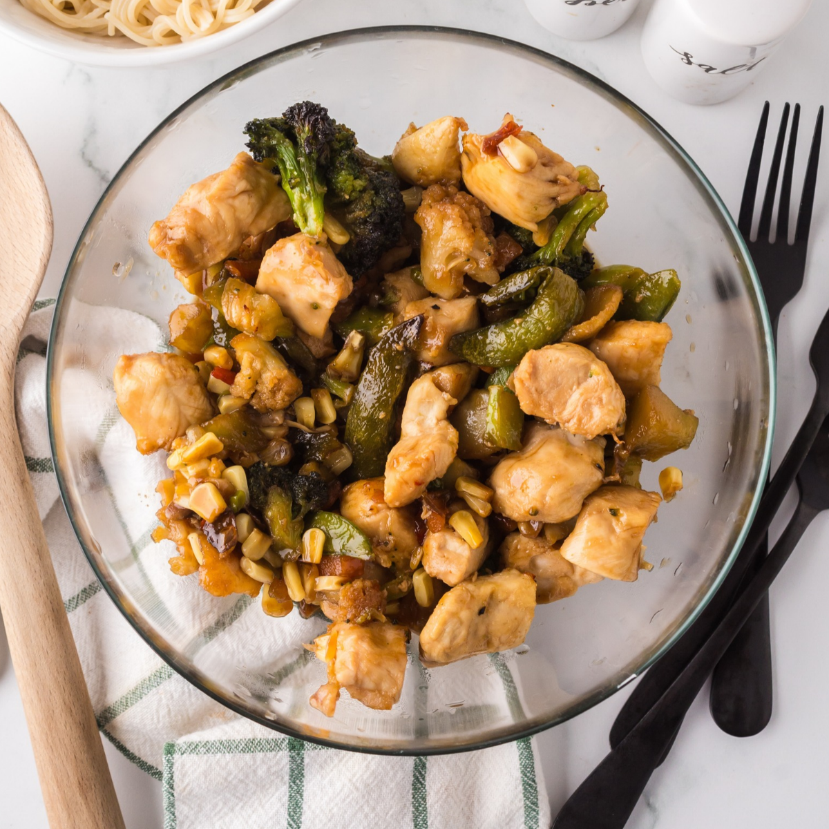 Air fryer chicken and broccoli tossed in teriyaki glaze with sesame seeds and green onions