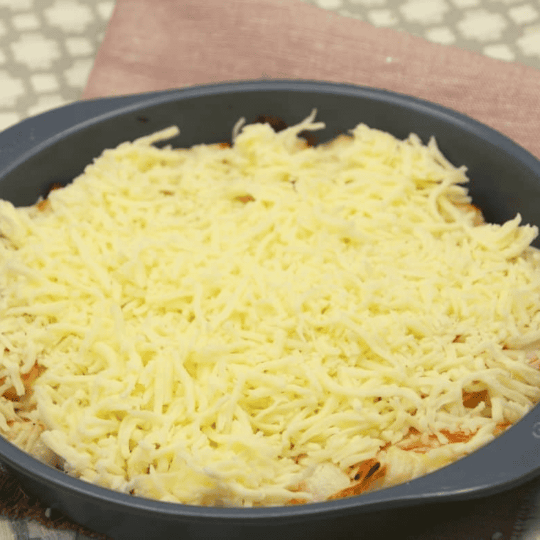 Crab casserole topped with shredded cheese ready to melt.