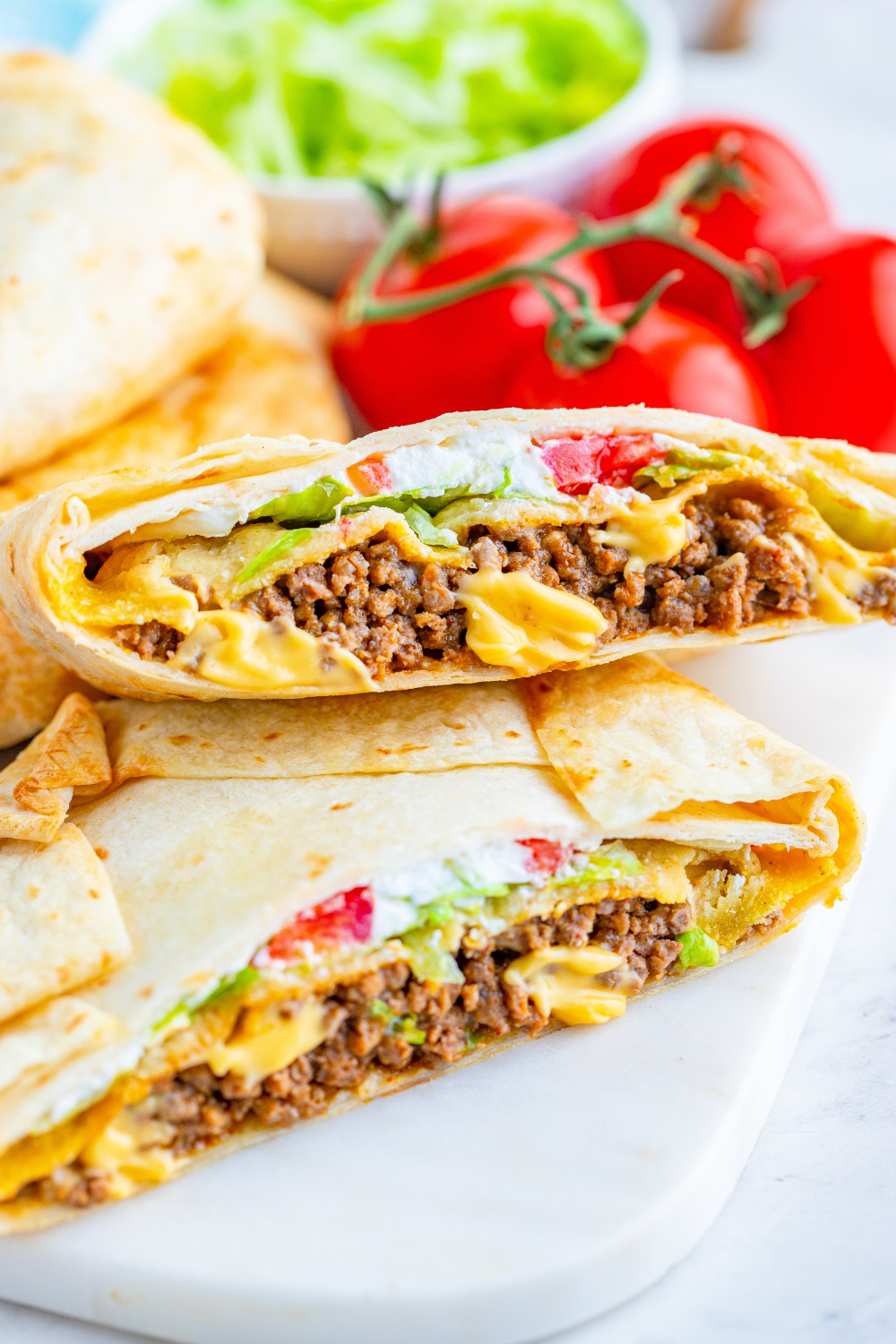 Air fryer crunchwrap sliced open showing layers of seasoned beef, nacho cheese, lettuce, and crispy tostada shell.