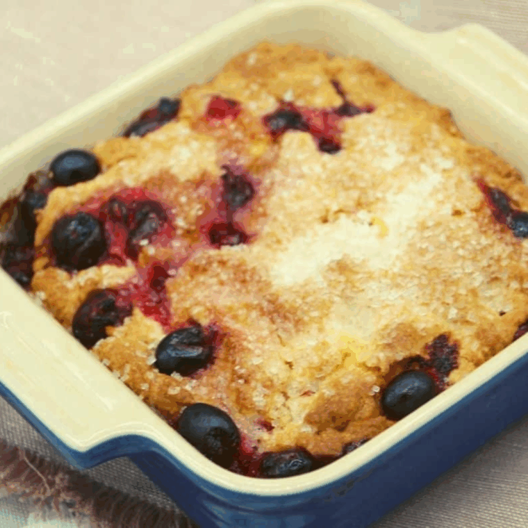 Slice of air fryer cranberry breakfast cake showing moist crumb and juicy cranberries.