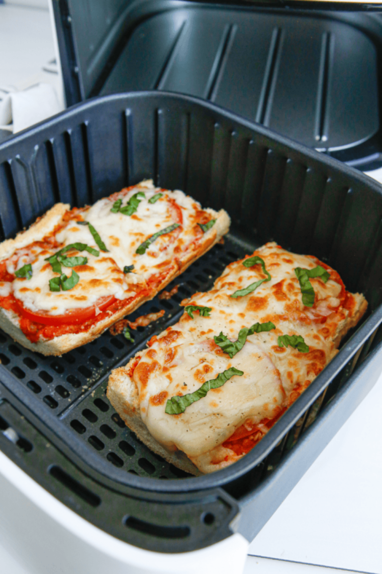 Air fryer French bread pizza slices served on a white plate with marinara dipping sauce on the side