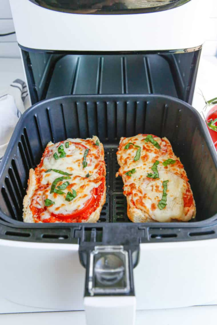Air fryer French bread pizza slices served on a white plate with marinara dipping sauce on the side