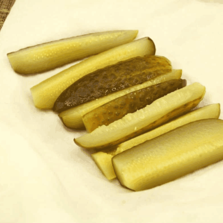 Draining pickle spears on paper towels to prevent soggy egg rolls.