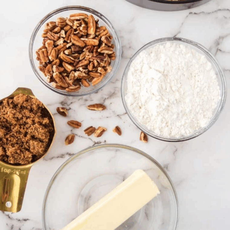 Mixing flour, brown sugar, butter, and cinnamon in a bowl, then folding in diced pecans for coffee cake topping.