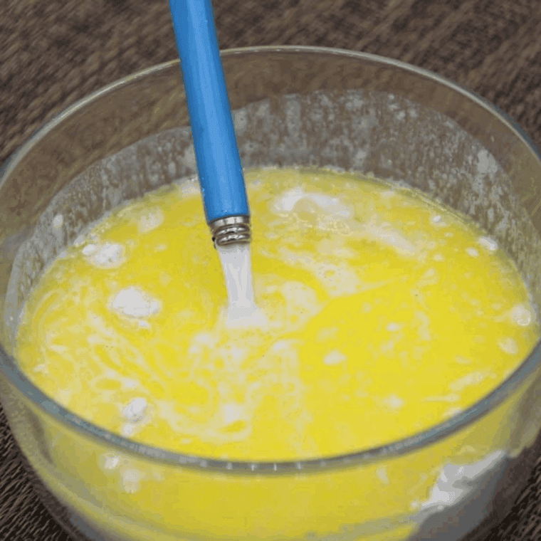 Mixing melted butter, milk, and vanilla extract into mug cake batter