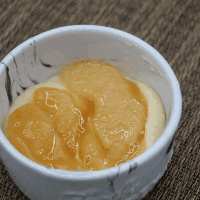 Spooned mug cake batter in ramekin with apple pie filling and cinnamon layer