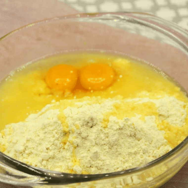 Mixing lemon cake mix, oil, and egg in a bowl to form cookie dough.