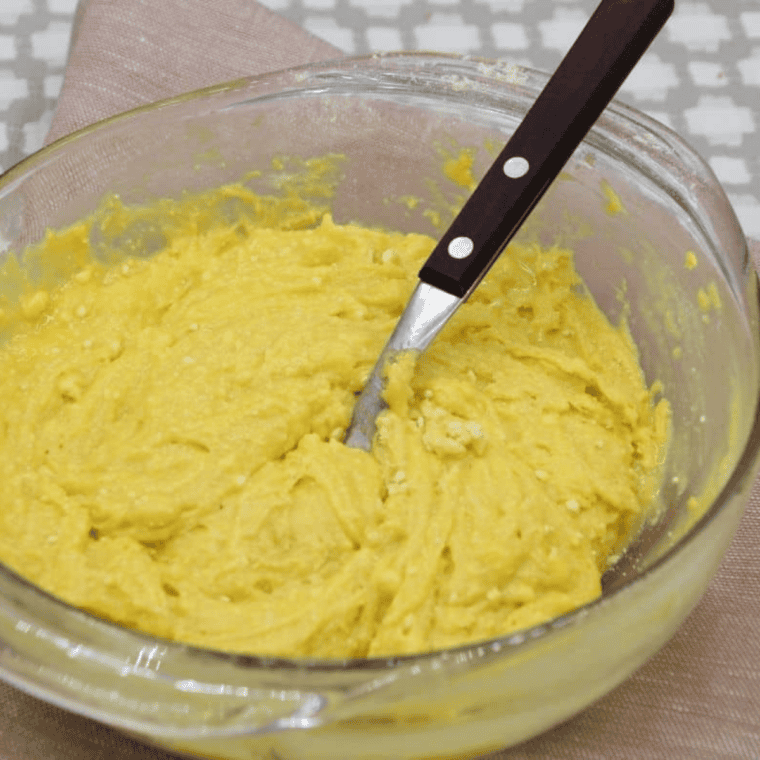 Rolling lemon cookie dough balls in powdered sugar before air frying.