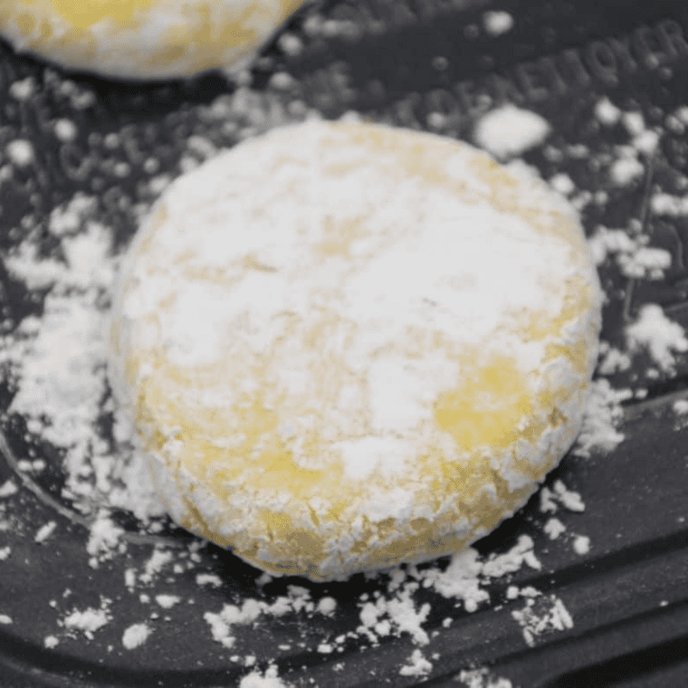 Lemon cookie dough placed in air fryer basket lined with parchment, cooking at 320&deg;F.