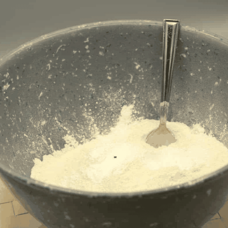 Mixing zucchini, flour, eggs, sugar, oil, baking powder, cinnamon, and salt into smooth muffin batter in a large bowl