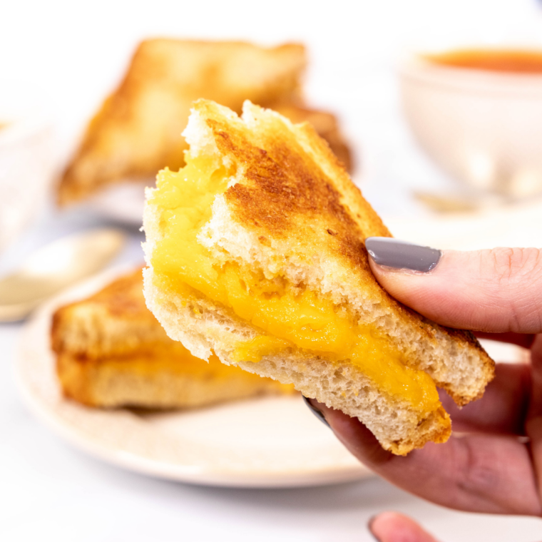 Homemade Ninja Crispi grilled cheese sandwich sliced in half with melted American cheese inside