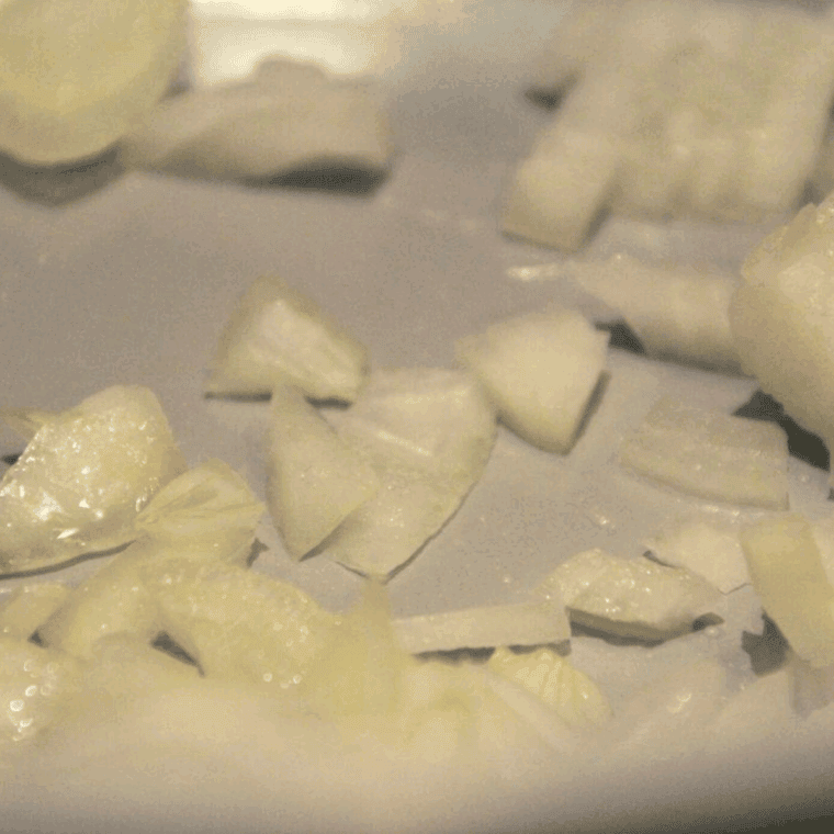 Onions sautéing in olive oil with rice and minced garlic in the Ninja Foodi.