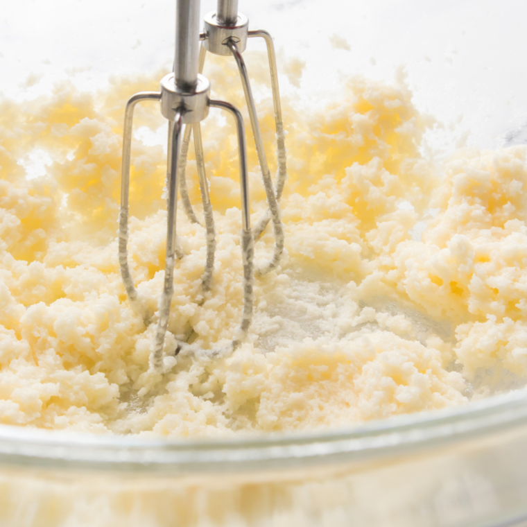 Creaming granulated sugar and vegetable oil in a glass mixing bowl until pale and glossy