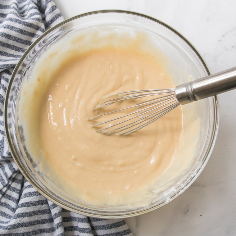 Adding flour, baking powder, baking soda, cinnamon, and salt to quick bread batter