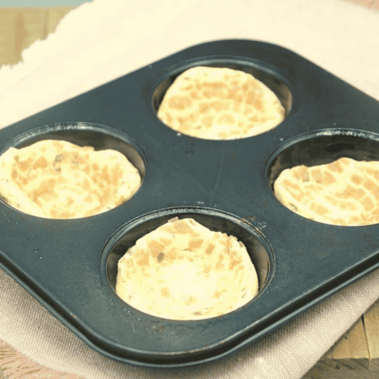 Cinnamon roll dough pressed into a muffin tin and filled with the cooked apple mixture