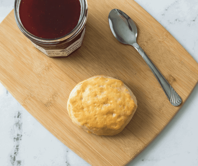Golden air fryer canned biscuits with fluffy layers inside, cooking evenly in an air fryer basket.