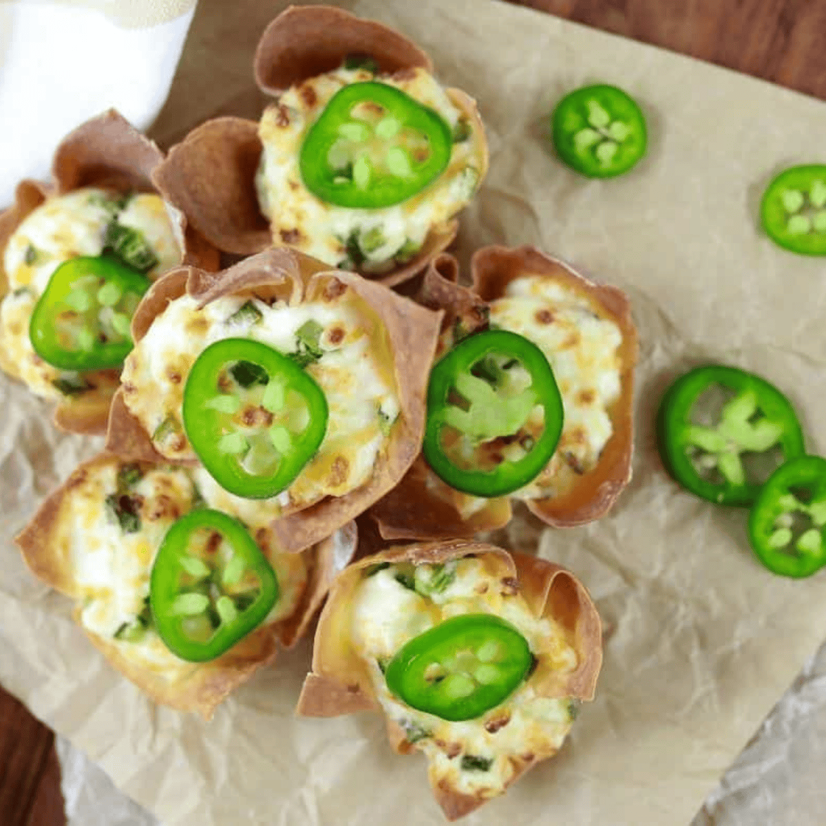 Crispy air fryer jalapeno popper wonton cups stacked on parchment paper