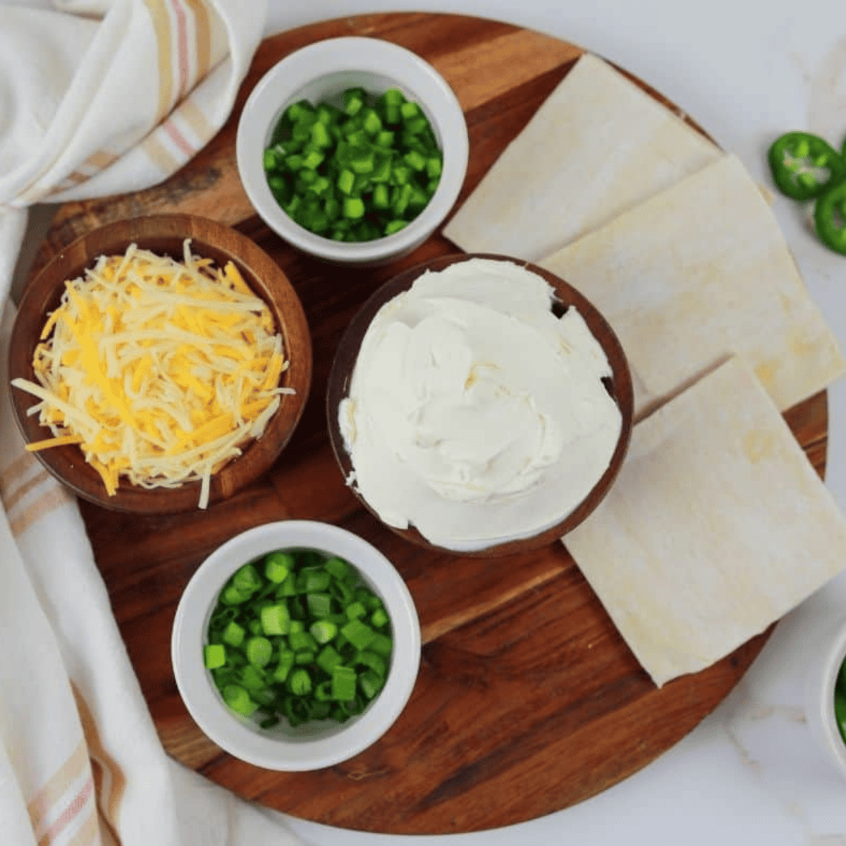 Ingredients for jalapeno popper wonton cups: wonton wrappers, cream cheese, jalapenos, green onions, and shredded cheese