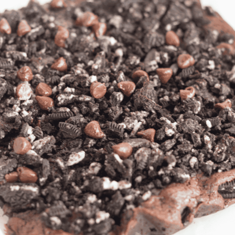 Fudgy air fryer Oreo brownies with crushed Oreo cookies baked into rich chocolate squares, gooey center dessert served warm on plate with cookies and cream texture