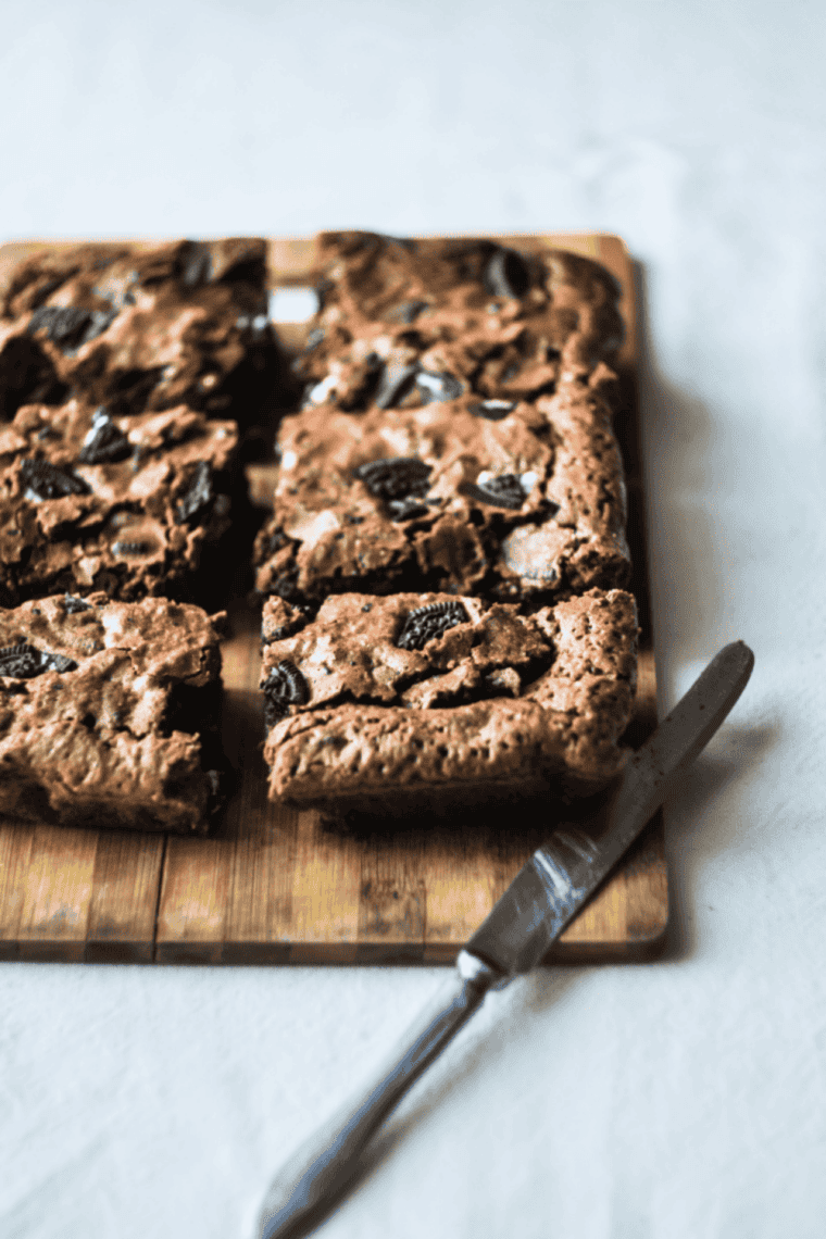 Fudgy air fryer Oreo brownies with crushed Oreo cookies baked into rich chocolate squares, gooey center dessert served warm on plate with cookies and cream texture