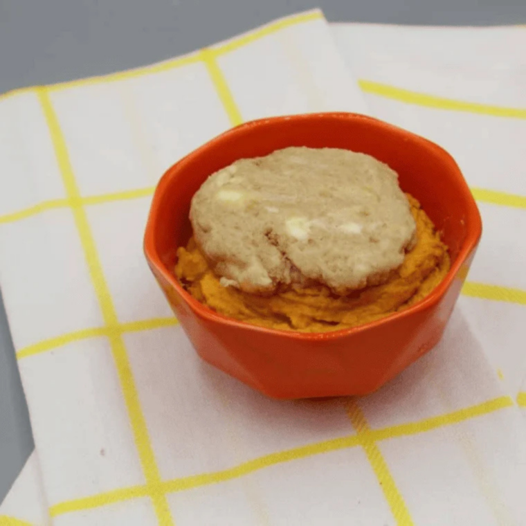 Brown sugar streusel crumbs scattered over pumpkin batter in a ramekin