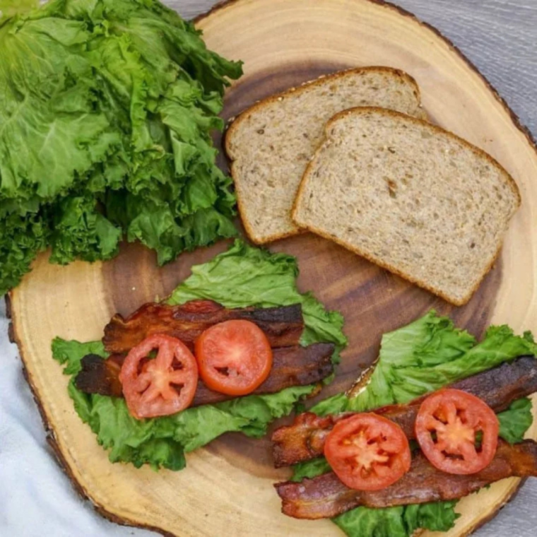 Buttered brioche buns toasting cut side down in a skillet until golden brown