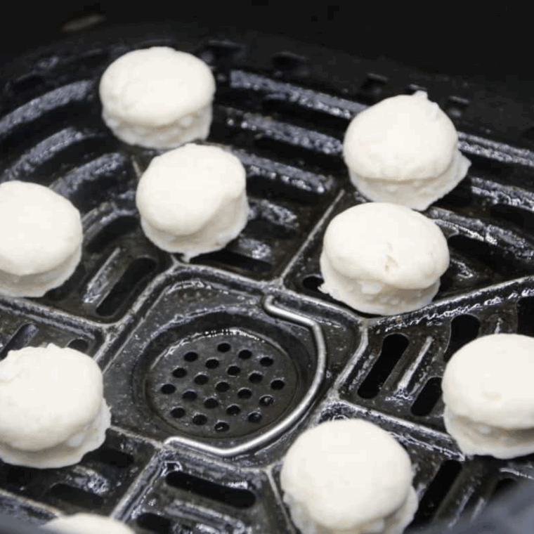 Air fryer basket sprayed with cooking spray, dough added, ready to cook at 320°F for 3–5 minutes.