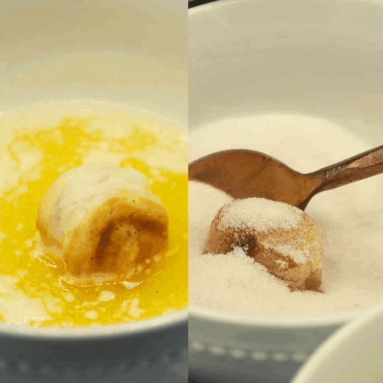 Cooked donut holes being dipped in melted butter and coated with cinnamon sugar.