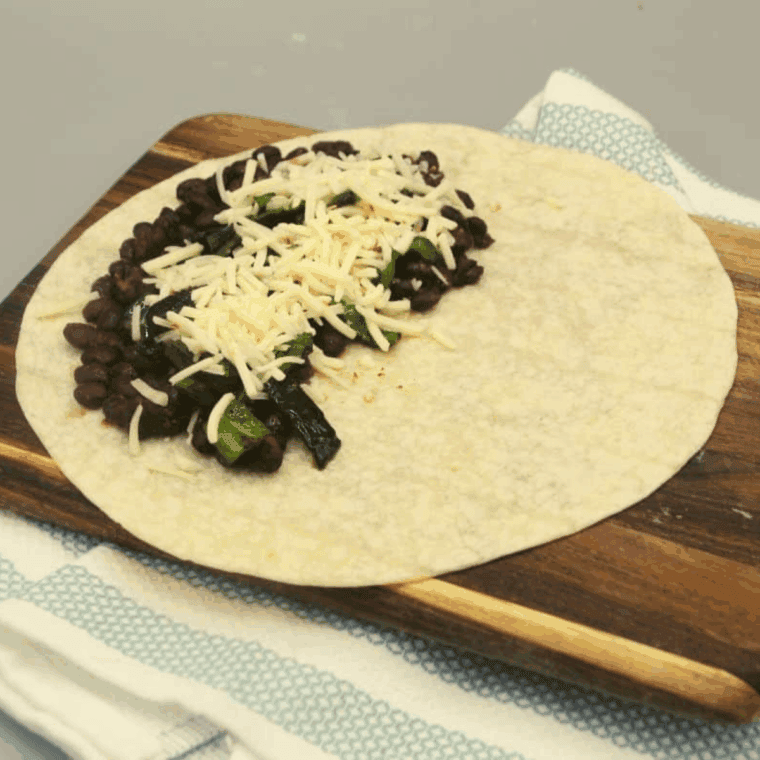 Tortilla filled with seasoned black beans, saut&eacute;ed poblano peppers, and shredded cheese