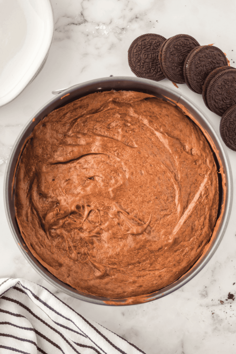 Refrigerating or freezing chocolate cheesecake to set and chill before serving.