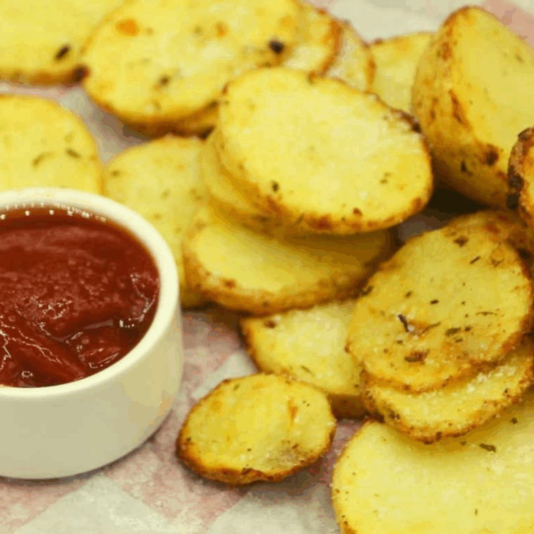 Golden, crispy air fryer potato chips coated with flavorful ranch seasoning in a bowl.