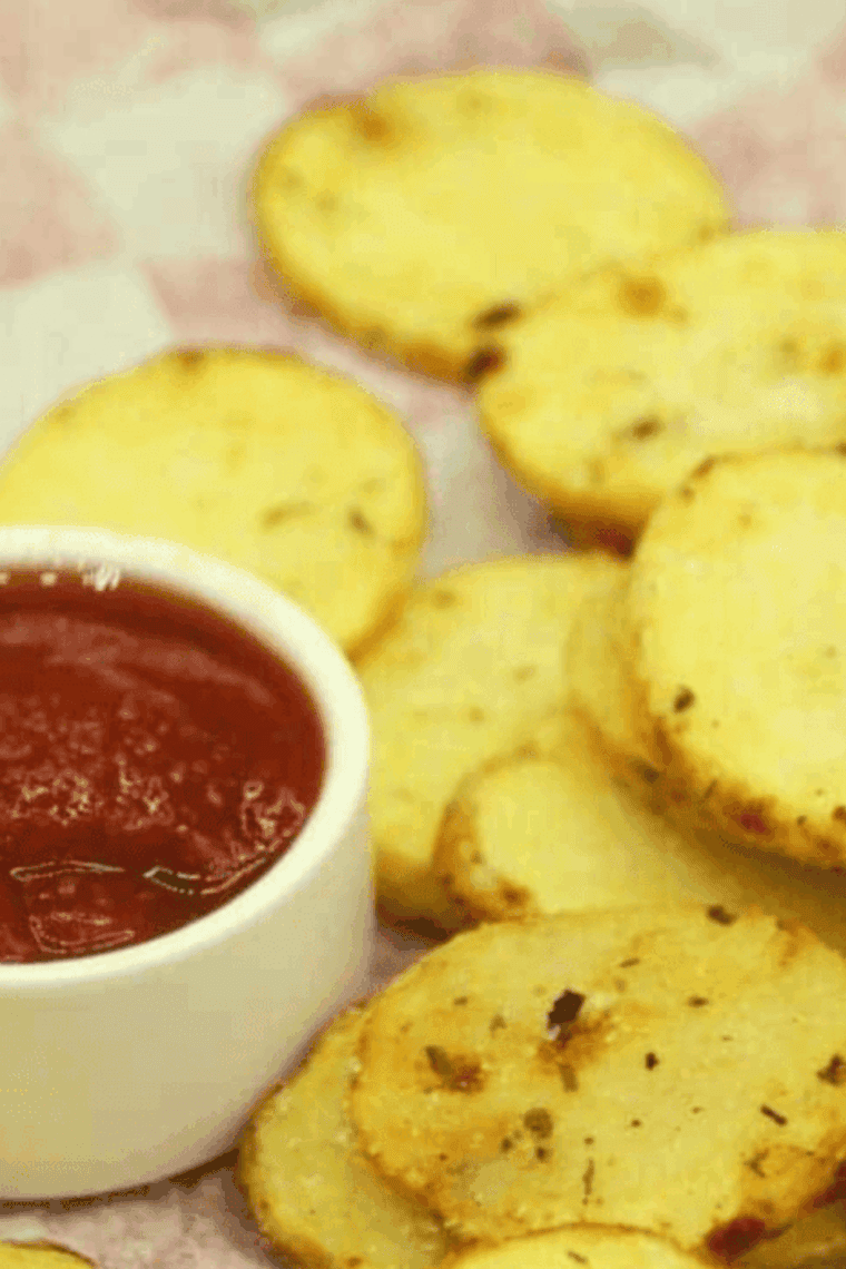Golden, crispy air fryer potato chips coated with tangy ranch seasoning in a bowl.