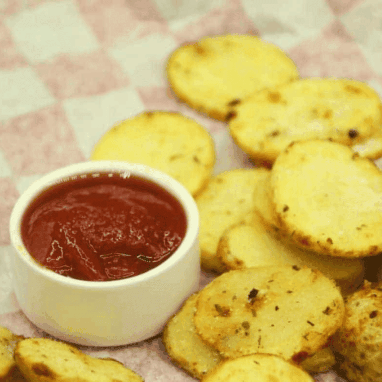 Golden, crispy air fryer potato chips coated in tangy ranch seasoning, served in a bowl.