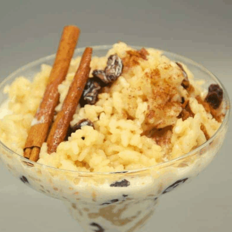 Featured image: Bowl of creamy Ninja Foodi Rum Raisin Rice Pudding topped with raisins and cinnamon
