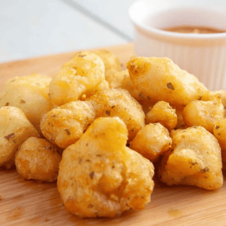 Frozen battered cauliflower placed into air fryer basket straight from the package.