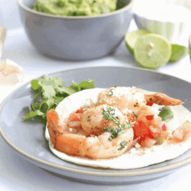Juicy air fryer shrimp fajitas with bell peppers and onions served on a plate.
