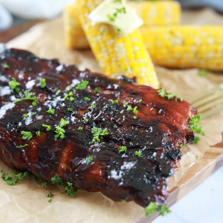 Grilled corn on the cob sizzling on a Blackstone griddle, brushed with melted butter and lightly charred on all sides.