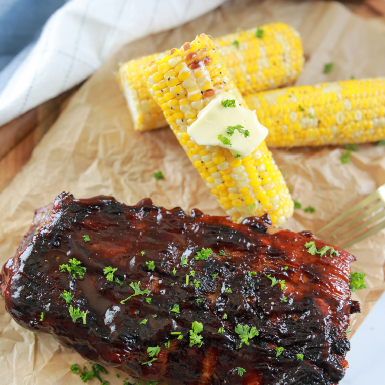 Buttery grilled corn on the cob cooking on a Blackstone griddle with golden char marks