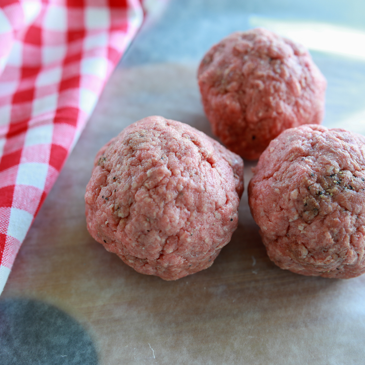 Loose ground chuck beef balls portioned on a tray and ready for making Blackstone smash burgers